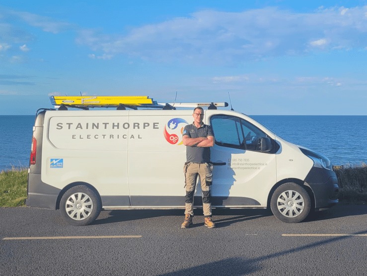David Stainthorpe standing beside the Stainthorpe Electrical van on the coast road